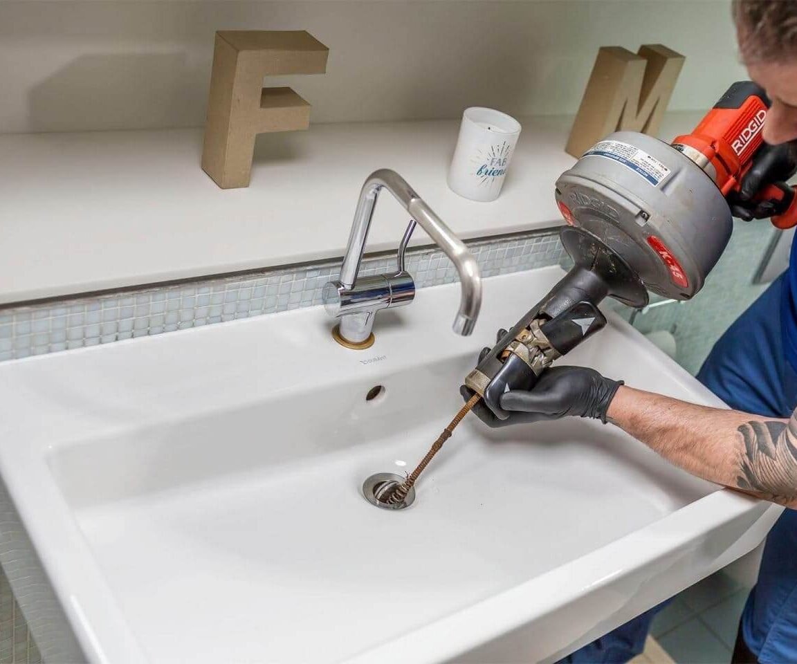 Técnico realizando desentupimento de vaso