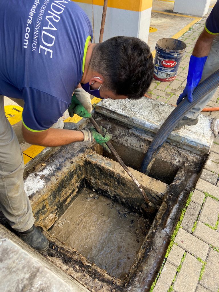 Profissional realizando limpeza de caixa de gordura